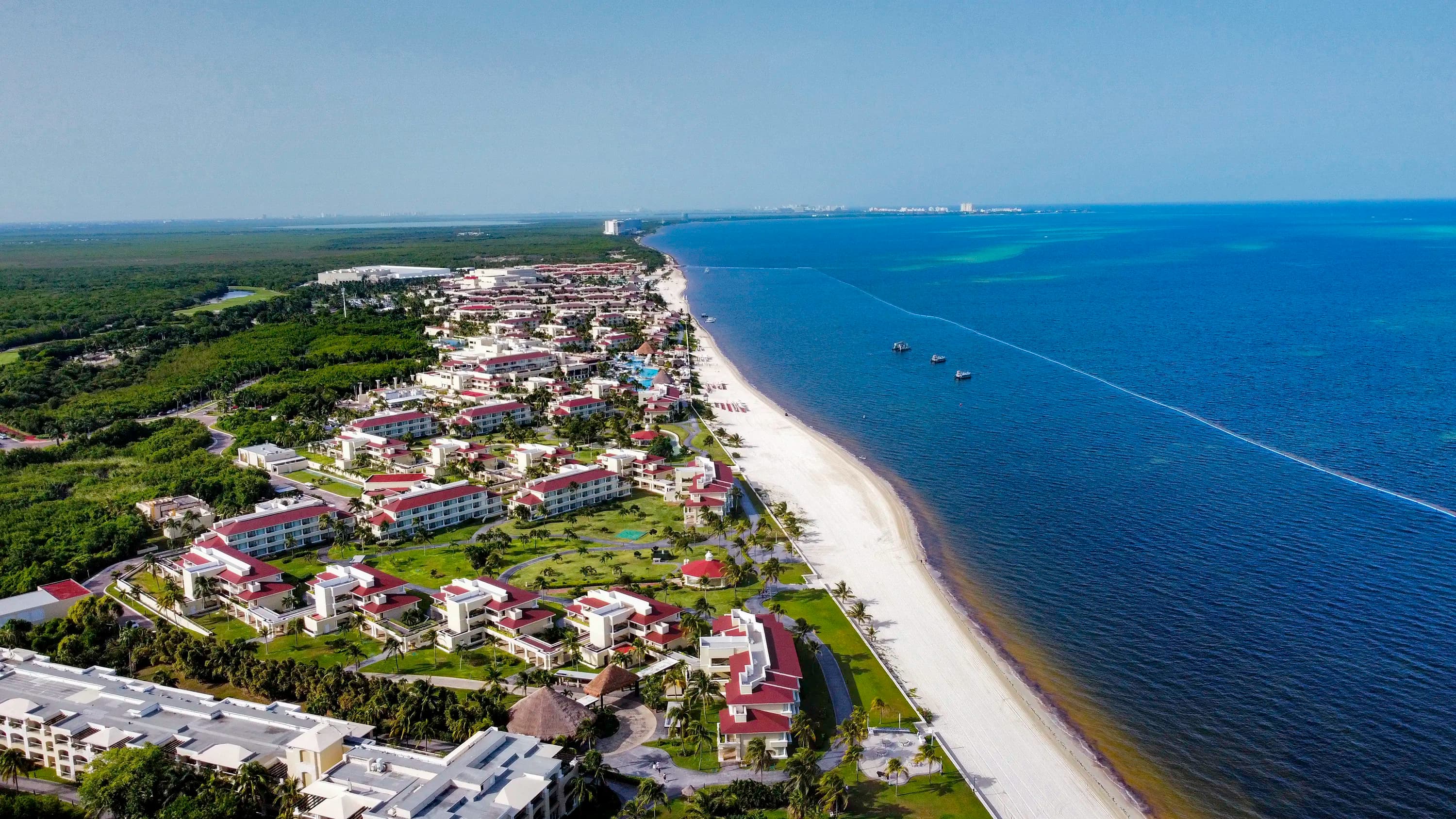 Aerial frame of a resort beach — sand, surf, structure in clean composition